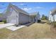 Home exterior featuring gray siding, a two-car garage, and well-maintained landscaping at 422 Switchgrass Dr, Summerville, SC 29486