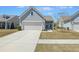 Well-manicured front yard with a paved driveway leading to a two-car garage and front entrance at 422 Switchgrass Dr, Summerville, SC 29486