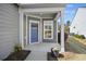 Inviting front porch with a blue door, gray siding, and natural lighting at 422 Switchgrass Dr, Summerville, SC 29486