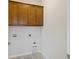 Laundry room features gray tile flooring and brown upper cabinets at 422 Switchgrass Dr, Summerville, SC 29486