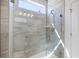 The walk-in shower features a glass door, tiled walls, built-in shelves, and a window for natural light at 422 Switchgrass Dr, Summerville, SC 29486