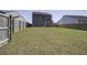 Wide backyard featuring a green lawn and a gray two-story home, surrounded by a wooden fence at 491 Fox Sparrow Ct, Summerville, SC 29486