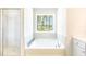 Bright bathroom with a soaking tub, a tiled shower, and a view of the backyard at 509 Yukon Ct, Lincolnville, SC 29485