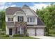 Charming two-story home featuring stone accents, a covered front porch, and a two-car garage at 517 Verdi Dr, Summerville, SC 29486