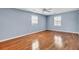 Bright bedroom with hardwood floors, light blue walls, ceiling fan, and natural light from two windows at 649 Pawley Rd, Mount Pleasant, SC 29464
