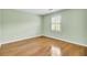Bright bedroom featuring wood floors, soft green walls, and window with shutter-style blinds at 649 Pawley Rd, Mount Pleasant, SC 29464