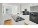 Well-lit kitchen featuring white cabinetry, a black backsplash, and a central island with a modern sink at 649 Pawley Rd, Mount Pleasant, SC 29464