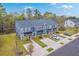 Aerial view of new blue townhomes showcasing driveways and lush surrounding greenery on a sunny day at 7803 Park Gate Dr, Charleston, SC 29418