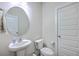 Clean, bright bathroom featuring a pedestal sink, round mirror, and modern fixtures at 7803 Park Gate Dr, Charleston, SC 29418