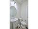 Bright half-bath featuring a pedestal sink, round mirror, and modern fixtures at 7803 Park Gate Dr, Charleston, SC 29418