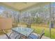 Covered patio featuring a glass-topped table and seating, with a view of the wooded yard at 7803 Park Gate Dr, Charleston, SC 29418