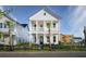 Charming two-story white home with double porches, a black fence, and a beautifully landscaped yard at 792 Clay Field Trl, Summerville, SC 29485