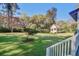 Spacious backyard featuring a charming guest house nestled among mature trees and greenery at 8115 Adams Run School Rd, Adams Run, SC 29426