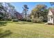 Spacious backyard featuring lush green grass, mature trees, and a charming shed at 8115 Adams Run School Rd, Adams Run, SC 29426