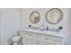 Elegant bathroom with a double sink vanity, round mirrors, and modern fixtures for a luxurious feel at 8115 Adams Run School Rd, Adams Run, SC 29426