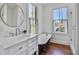 Bright bathroom with a clawfoot tub, marble counters, and two windows at 8115 Adams Run School Rd, Adams Run, SC 29426
