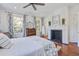 Bright bedroom with a fireplace, wood floors, a ceiling fan, and patterned curtains at 8115 Adams Run School Rd, Adams Run, SC 29426