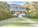 Inviting two-story home with a charming porch, brick foundation, well-manicured lawn, and lush greenery at 8115 Adams Run School Rd, Adams Run, SC 29426
