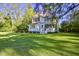 Charming two-story home featuring a well-manicured lawn and mature trees draped with Spanish moss at 8115 Adams Run School Rd, Adams Run, SC 29426
