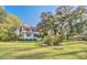 Charming two-story home featuring a manicured lawn and mature trees draped with Spanish moss at 8115 Adams Run School Rd, Adams Run, SC 29426