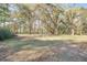 Large lot featuring lush green grass and mature trees draped with Spanish moss at 8115 Adams Run School Rd, Adams Run, SC 29426