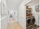 Bright hallway leads to a laundry area with modern washer and dryer units and custom shelves at 873 Tupelo Bay Dr, Mount Pleasant, SC 29464