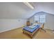 Cozy bedroom in converted attic featuring sloped ceiling and bright natural light from a large window at 891 Wynford Ct, Mount Pleasant, SC 29464
