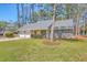 Single-story home with lush front lawn, mature trees, a two-car garage, and inviting curb appeal at 891 Wynford Ct, Mount Pleasant, SC 29464