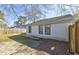 The backyard offers ample space, with a view of the home's exterior with window features at 9861 Levenshall Dr, Ladson, SC 29456