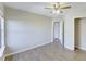 Bright bedroom with wood floors, ceiling fan, closet, and a door leading to the hallway at 9861 Levenshall Dr, Ladson, SC 29456