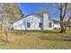 Rear exterior of home with windows, chimney and manicured yard at 9861 Levenshall Dr, Ladson, SC 29456