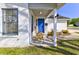 Welcoming front porch featuring a blue door, two wooden rocking chairs and white brick at 9861 Levenshall Dr, Ladson, SC 29456
