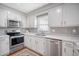 Well-lit kitchen featuring stainless steel appliances, white cabinets, and a stylish gray tiled backsplash at 101 Plantation Dr, Summerville, SC 29485