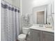 Well-lit bathroom with a modern vanity, large mirror, and shower with decorative curtain at 109 Airy Dr, Summerville, SC 29486