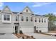 Beautiful townhome exterior with attached garages and manicured landscaping under a blue sky at 110 Brown Swiss Cir, Summerville, SC 29483