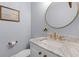 Chic powder room featuring a marble countertop, gold fixtures, and a decorative mirror at 1100 Sea Island Crossing Ln, Mount Pleasant, SC 29464