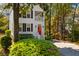 Beautiful two-story home featuring a porch, red front door, and a well manicured lawn at 1100 Sea Island Crossing Ln, Mount Pleasant, SC 29464