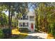 Charming two-story home features a red front door, white trim, and lush landscaping at 1100 Sea Island Crossing Ln, Mount Pleasant, SC 29464