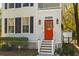 Close up of the front of the house featuring a red door, sidelights, and green shrubbery at 1100 Sea Island Crossing Ln, Mount Pleasant, SC 29464
