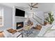 Elegant living room with a fireplace, staircase, neutral furniture, and a stylish ceiling fan at 1100 Sea Island Crossing Ln, Mount Pleasant, SC 29464