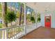 Spacious porch featuring wood floors, white railings, ferns, and a red door at 1100 Sea Island Crossing Ln, Mount Pleasant, SC 29464