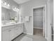 Bright bathroom featuring a double sink vanity, gray tile floor and an open closet/storage area at 112 Brown Swiss Cir, Summerville, SC 29483
