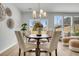 Cozy dining area with a round table, modern chandelier, and natural light from the sliding door at 112 Brown Swiss Cir, Summerville, SC 29483