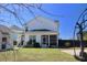 Backyard view features a well-maintained lawn, a basketball court, and an enclosed screened-in porch at 112 Carpenter St, Summerville, SC 29486