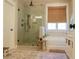 Bathroom with a glass-door shower and a bathtub adjacent to a window with a bamboo shade at 112 Carpenter St, Summerville, SC 29486