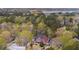 Aerial view of a neighborhood showcasing the red two-story home nestled among lush trees with a lake visible in the distance at 1149 Lands End Dr, Hanahan, SC 29410