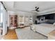 Bright main bedroom features a tray ceiling, ceiling fan, ensuite bathroom, and a decorative wood cabinet at 1149 Lands End Dr, Hanahan, SC 29410