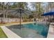 Beautiful in-ground pool surrounded by a lush backyard with a large umbrella and manicured landscaping at 1149 Lands End Dr, Hanahan, SC 29410