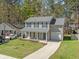 Attractive two-story home featuring a covered front porch, attached garage, and manicured lawn at 115 Trickle Dr, Summerville, SC 29483
