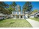Inviting two-story home with a covered porch, attached garage, and lush green lawn at 115 Trickle Dr, Summerville, SC 29483